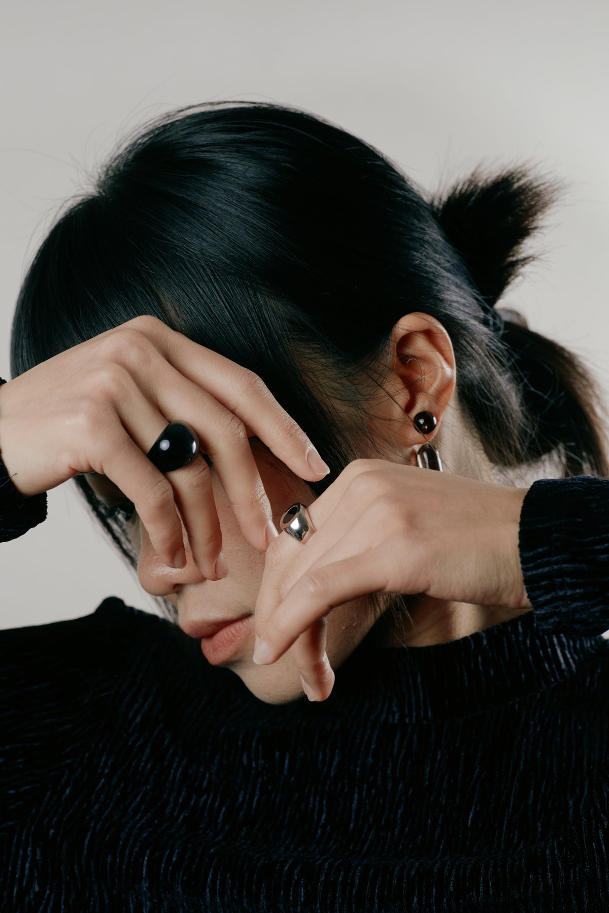 Obsidian Egg Silhouette Ring — Person with hands covering face against a neutral background