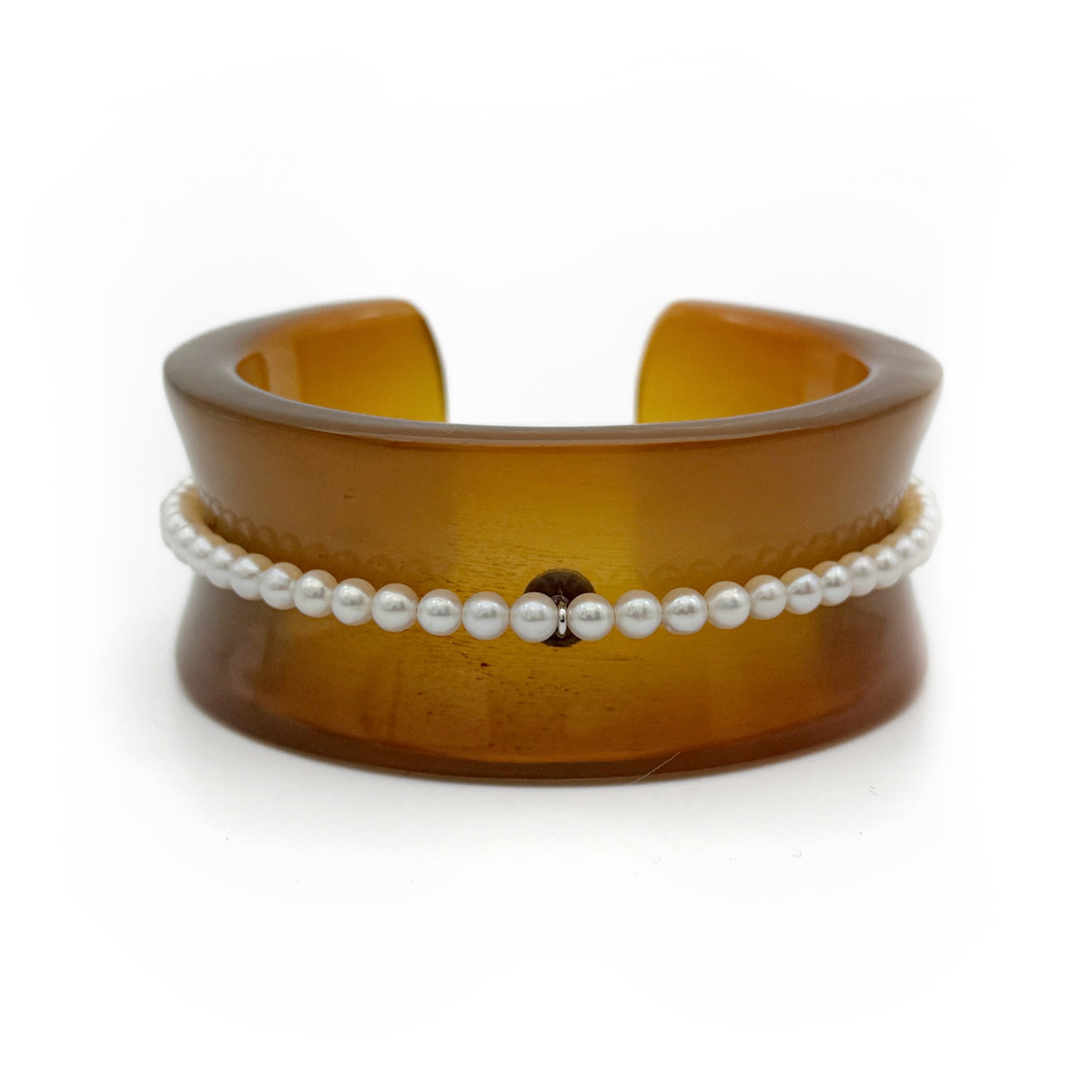 Pearl Inlay Open Cuff Horn Bracelet — Brown cuff bracelet with a white pearl bracelet on top on a white background
