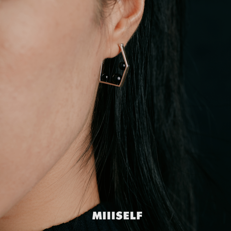 Pentagon Onyx Earrings — Close-up of an earring worn by a person with 'MIIISELF' branding.