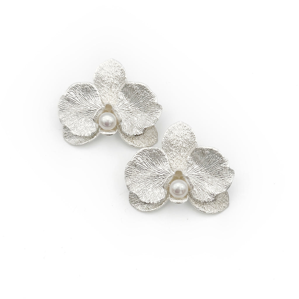 Phalaenopsis Orchid Convertible Earrings — Silver flower-shaped earrings with pearls on a white background