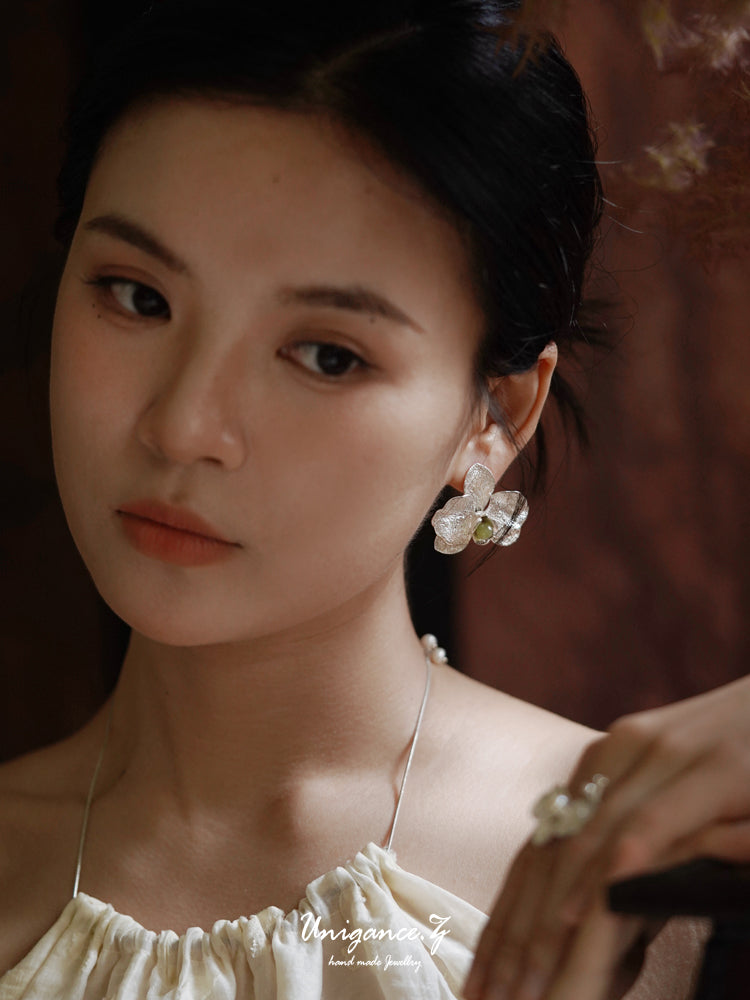 Phalaenopsis Orchid Convertible Earrings — Close-up of a person wearing earrings with a blurred background
