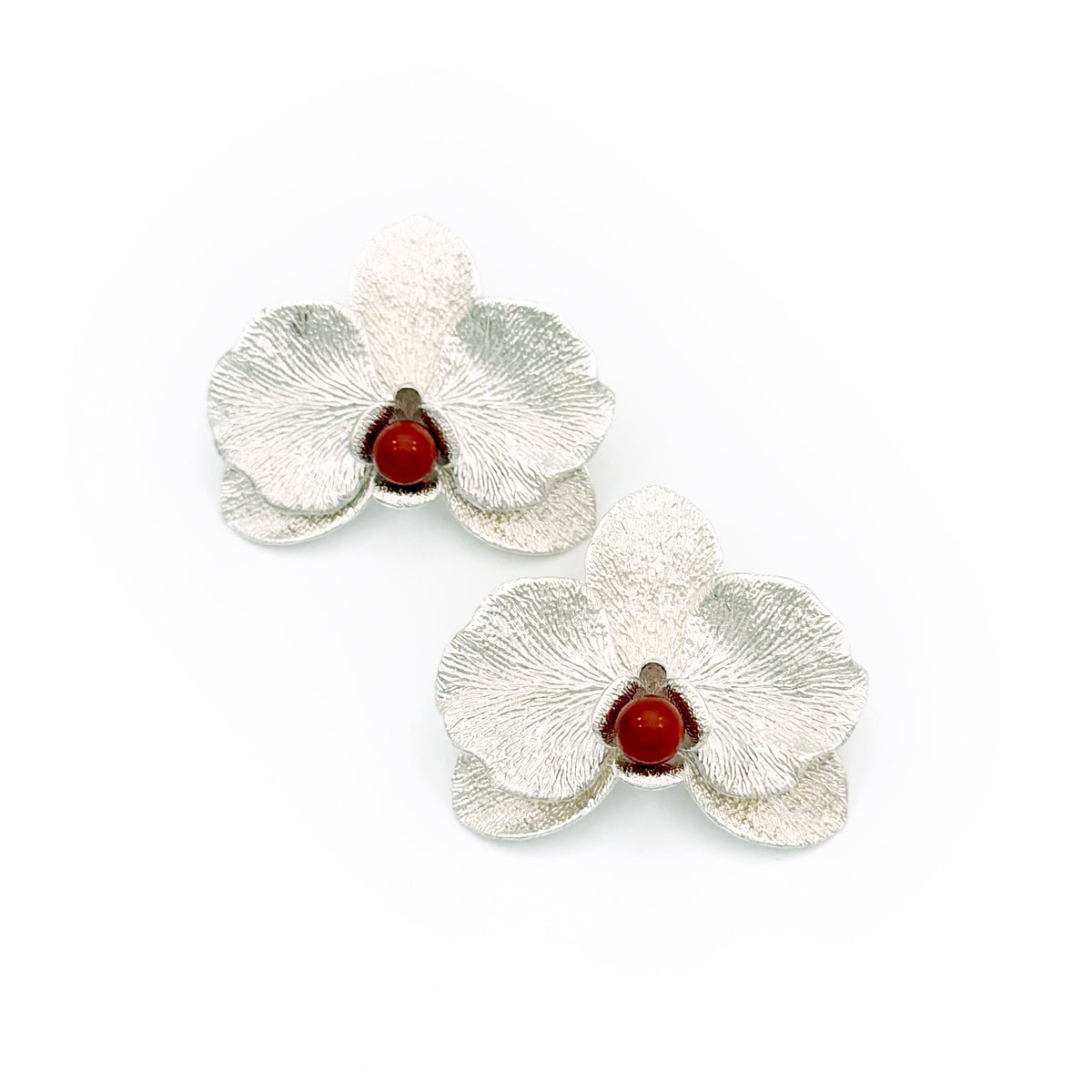 Phalaenopsis Orchid Convertible Earrings — Silver flower-shaped earrings with red centers on a white background