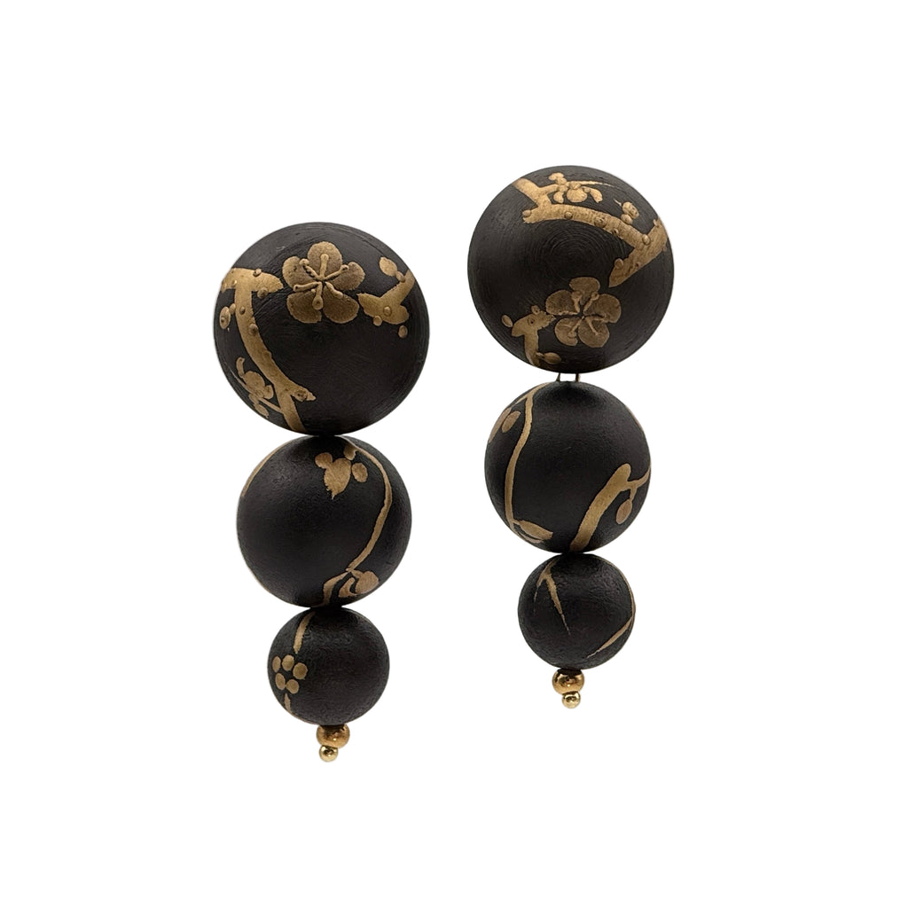 Plum Blossom Lacquer Quasi-Maki-e Earrings — Black earrings with gold floral patterns on a white background