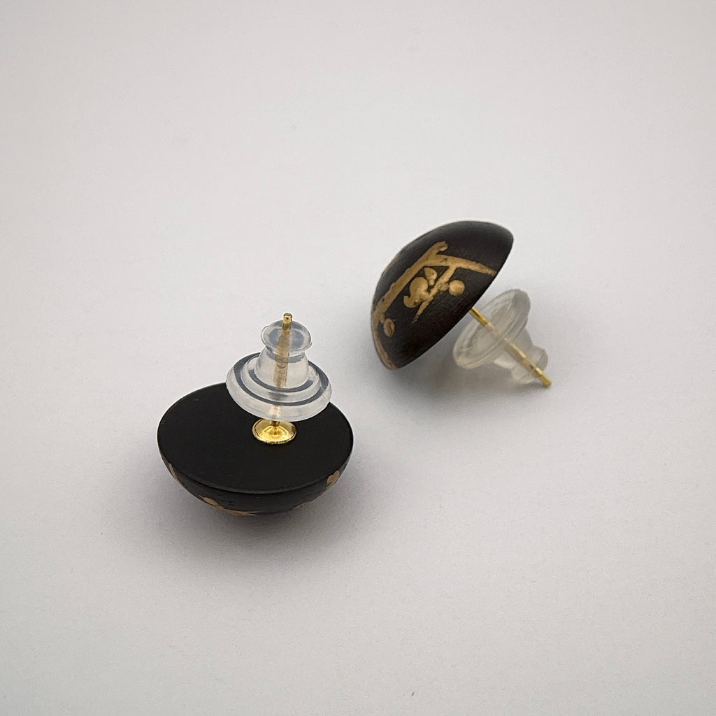 Plum Blossom Lacquer Quasi-Maki-e Stud Earrings — Two black and gold earrings on a light gray background