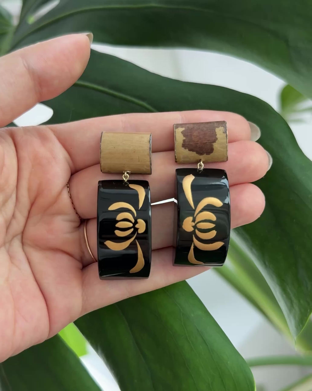 Handcrafted bamboo lacquer earrings with natural grain texture and delicate gold floral detailing, blending organic materials with quiet elegance.