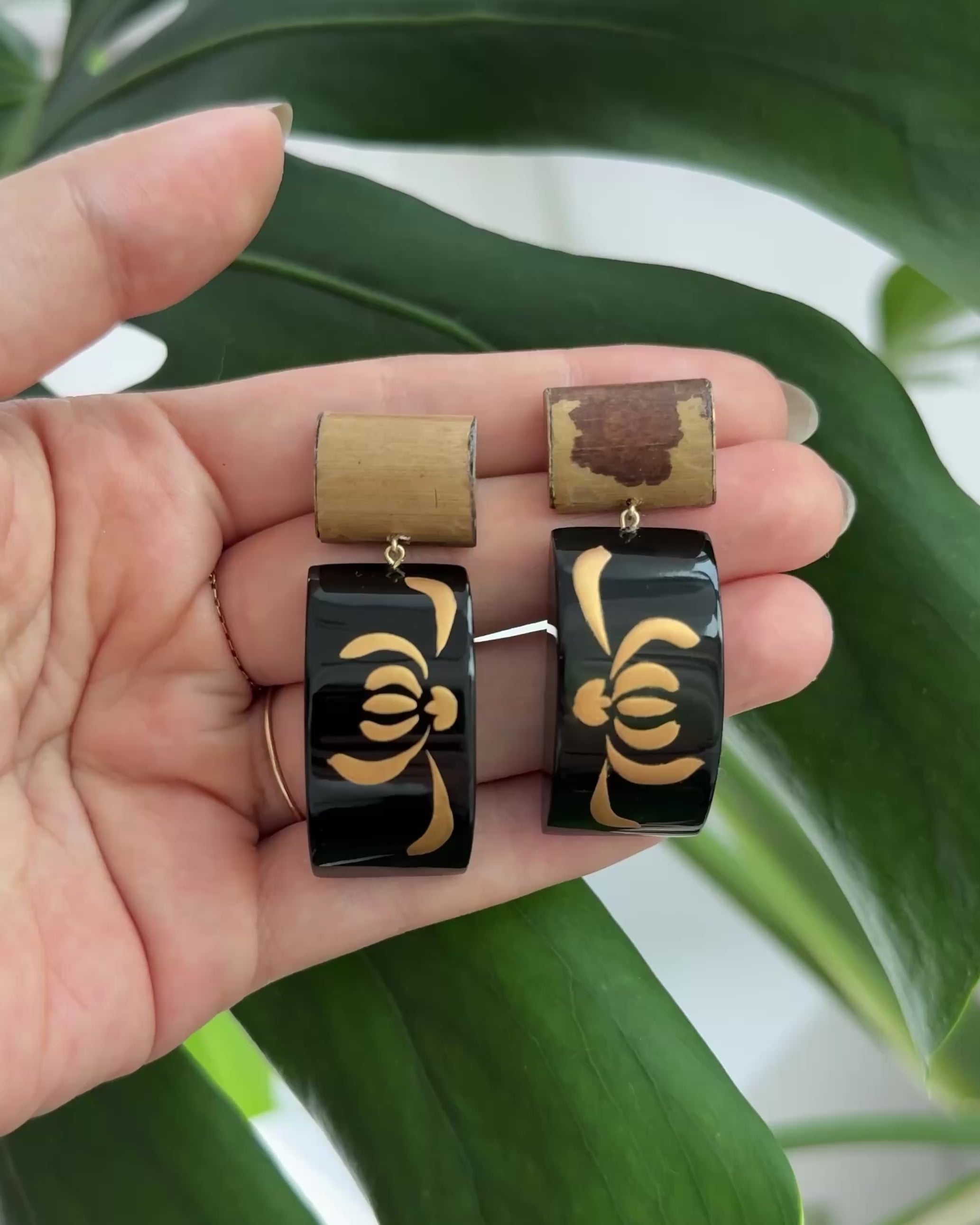 Handcrafted bamboo lacquer earrings with natural grain texture and delicate gold floral detailing, blending organic materials with quiet elegance.