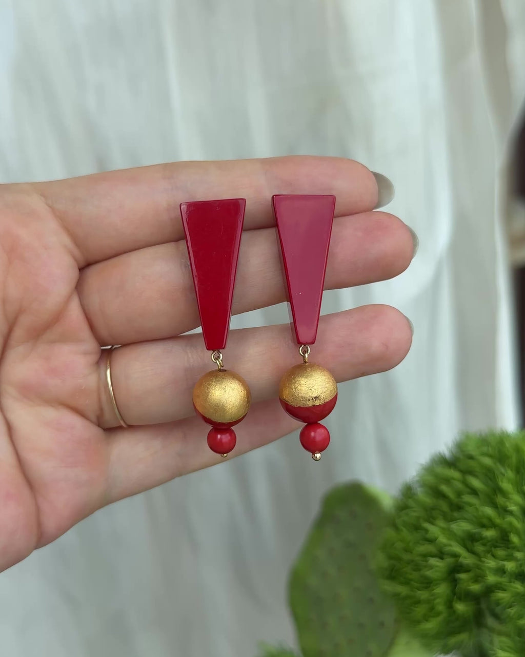 Handcrafted red lacquer triangular earrings inspired by mountain silhouettes, featuring gold leaf detailing and a black jade drop, each piece uniquely made using traditional Chinese lacquer techniques.