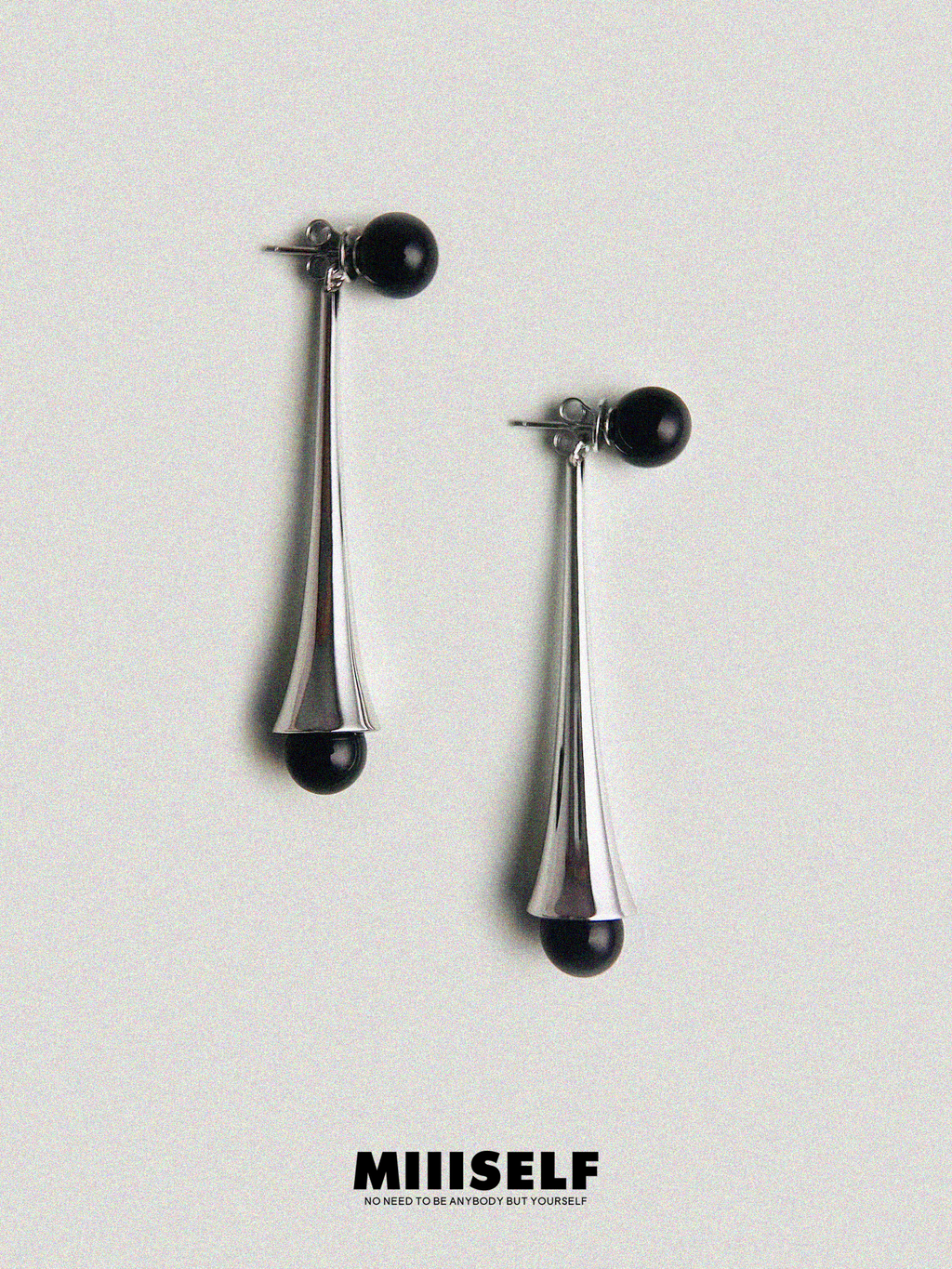 Rain Drop Onyx Convertible Earrings — Pair of silver earrings with black beads on a light gray background, featuring the
