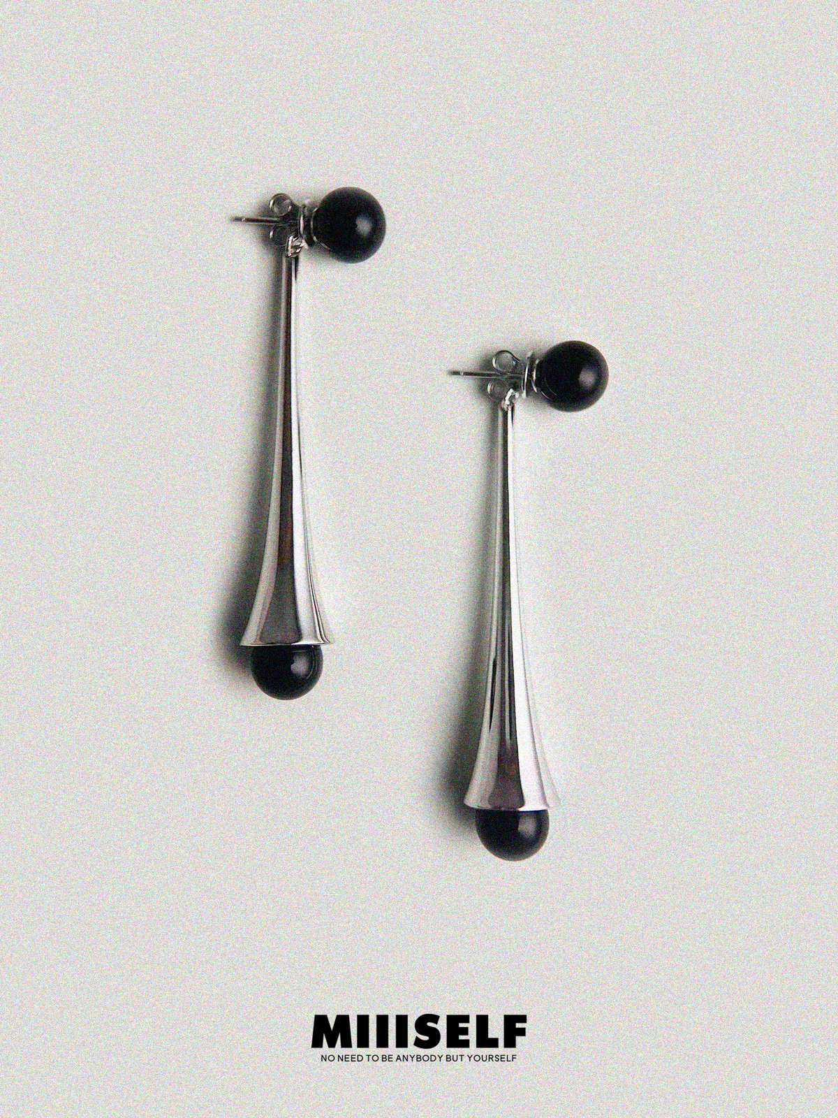Rain Drop Onyx Convertible Earrings — Pair of silver earrings with black beads on a light gray background, featuring the