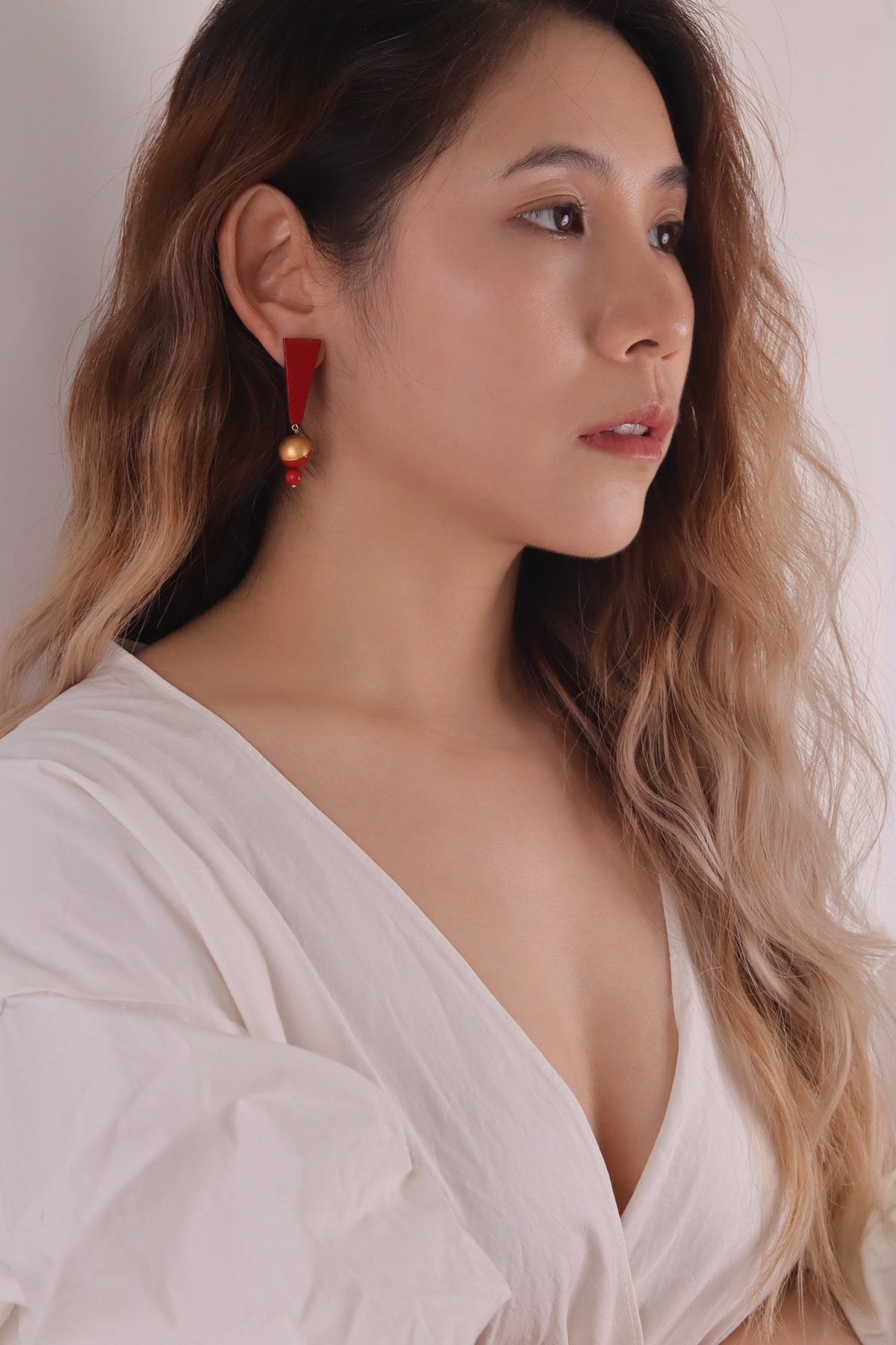 Red Mountain Lacquer Quasi-Maki-e Earrings — Woman wearing a white top with a plain background