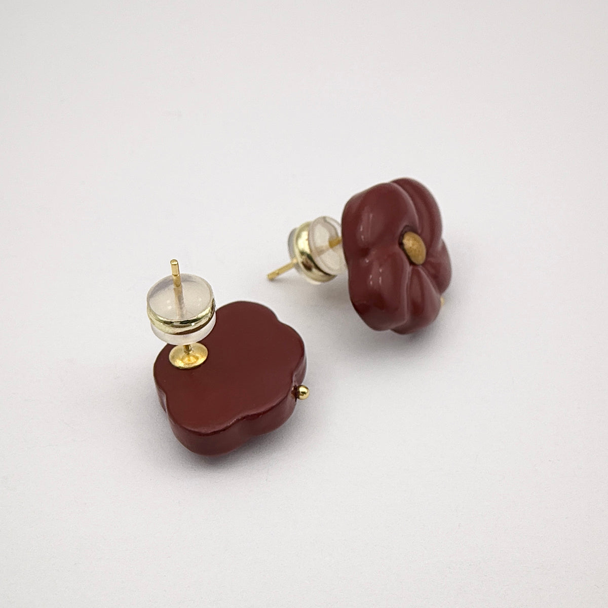 Red Peach Blossom Lacquer Quasi-Maki-e Earrings — Pair of brown earrings with gold accents on a light gray background