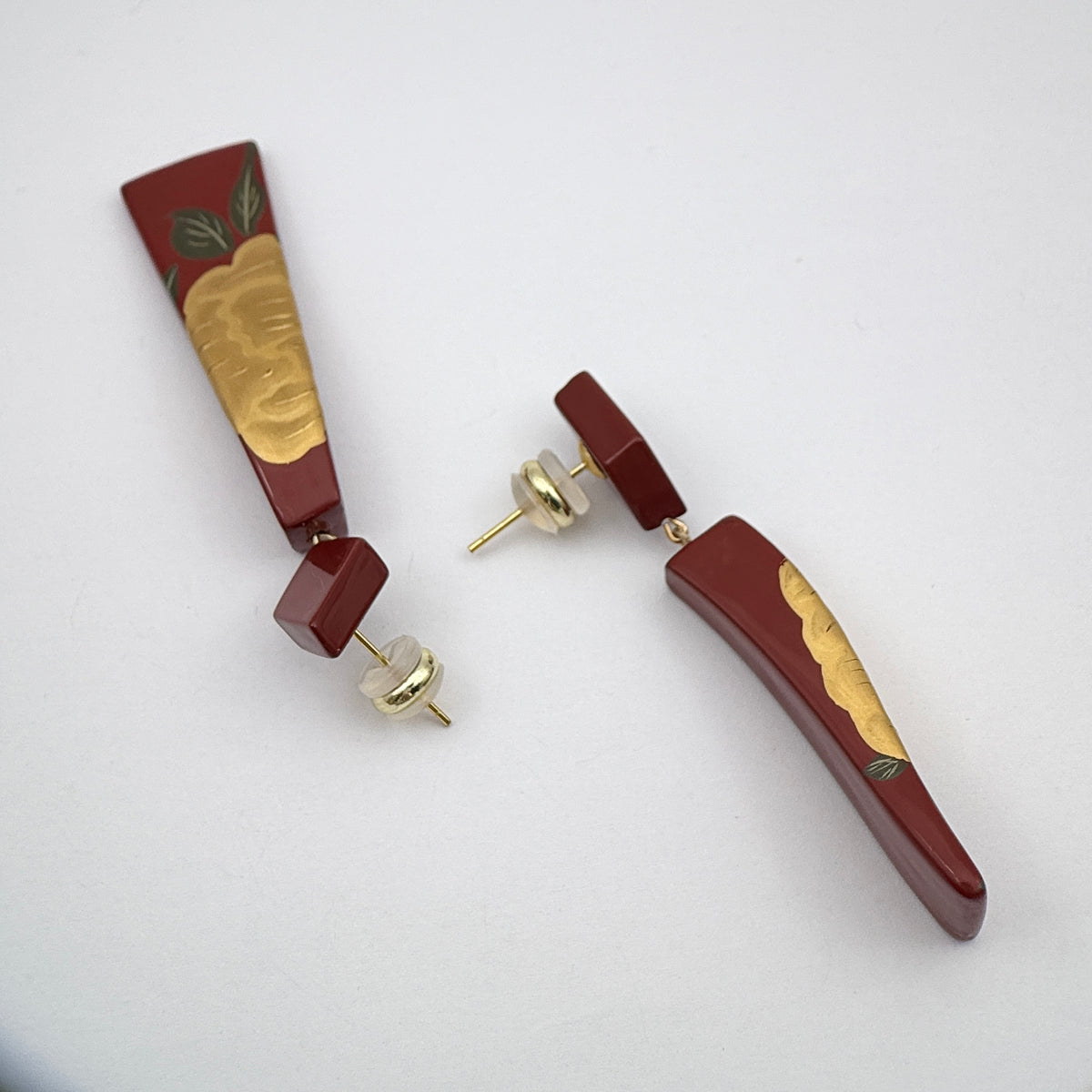 Red Peony Lacquer Quasi-Maki-e Earrings — Pair of maroon and gold earrings on a light gray background