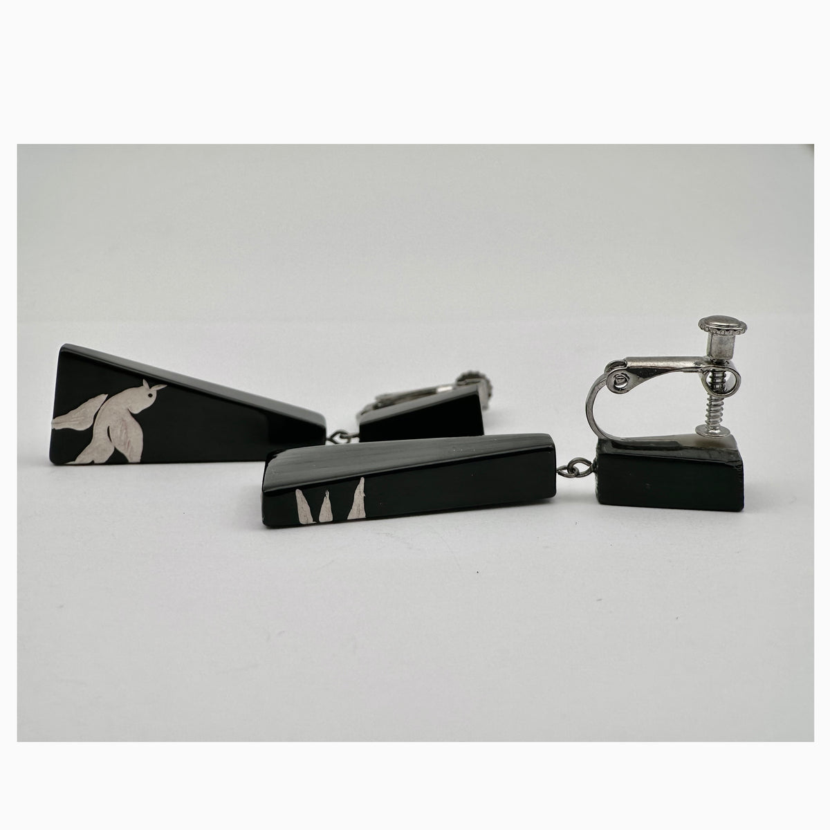 Rising Joy Lacquer Quasi-Maki-e Earrings — Black and silver cufflinks on a light gray background