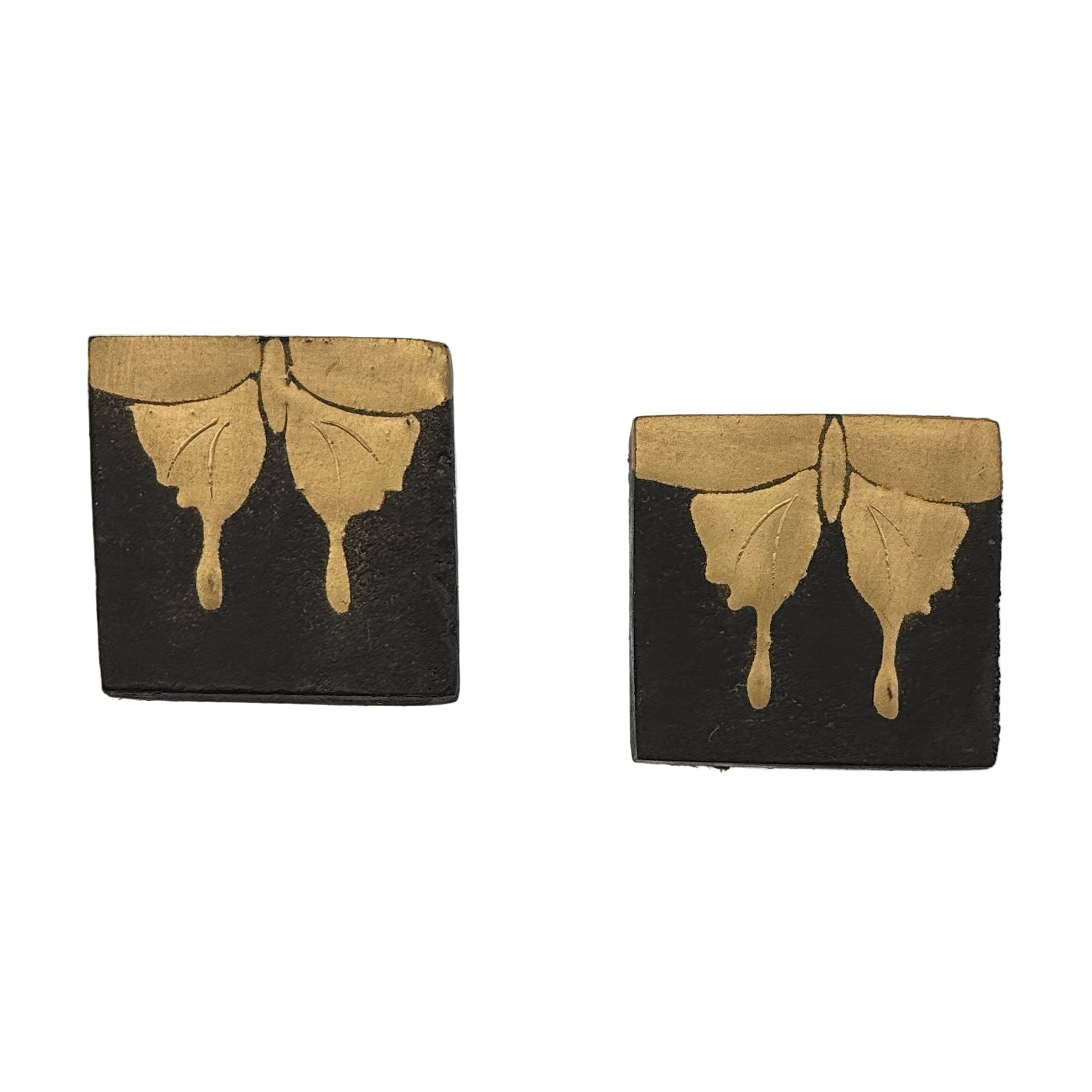 Two black and gold butterfly-themed coasters on a white background