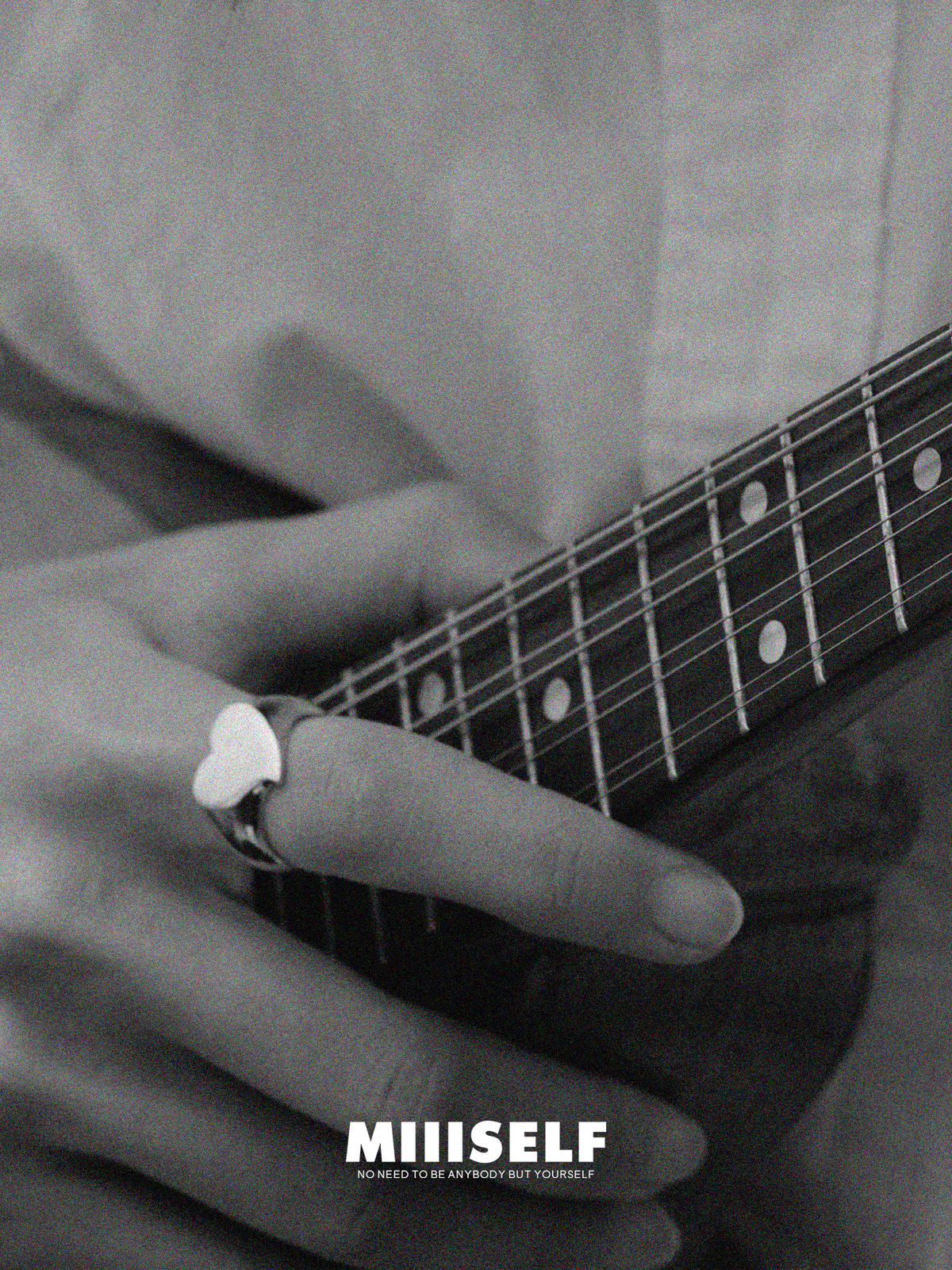 Silver Heart Signet Ring — Close-up of a person playing guitar with a heart-shaped ring, featuring the brand 'Miiiself'.