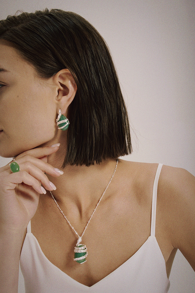 Silver Serpent Guardian Necklace — Woman wearing a necklace and earrings with a plain background