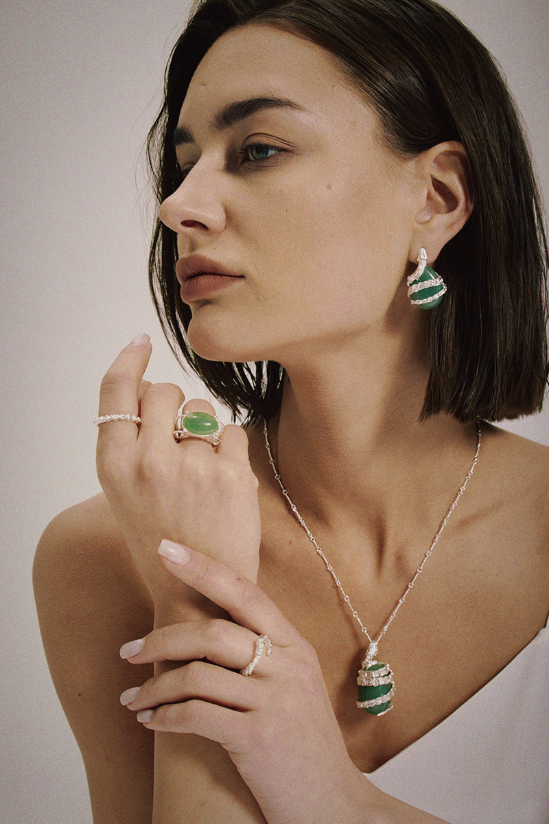 Silver Serpent Guardian Stud Earrings — Woman wearing emerald green and silver jewelry including earrings, ring, and