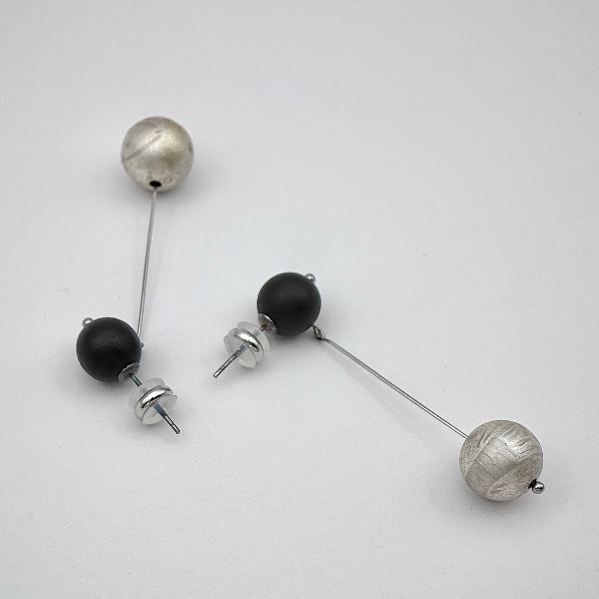 Silverfish Lacquer Quasi-Maki-e Earrings — Pair of earrings with black and silver beads on a white background