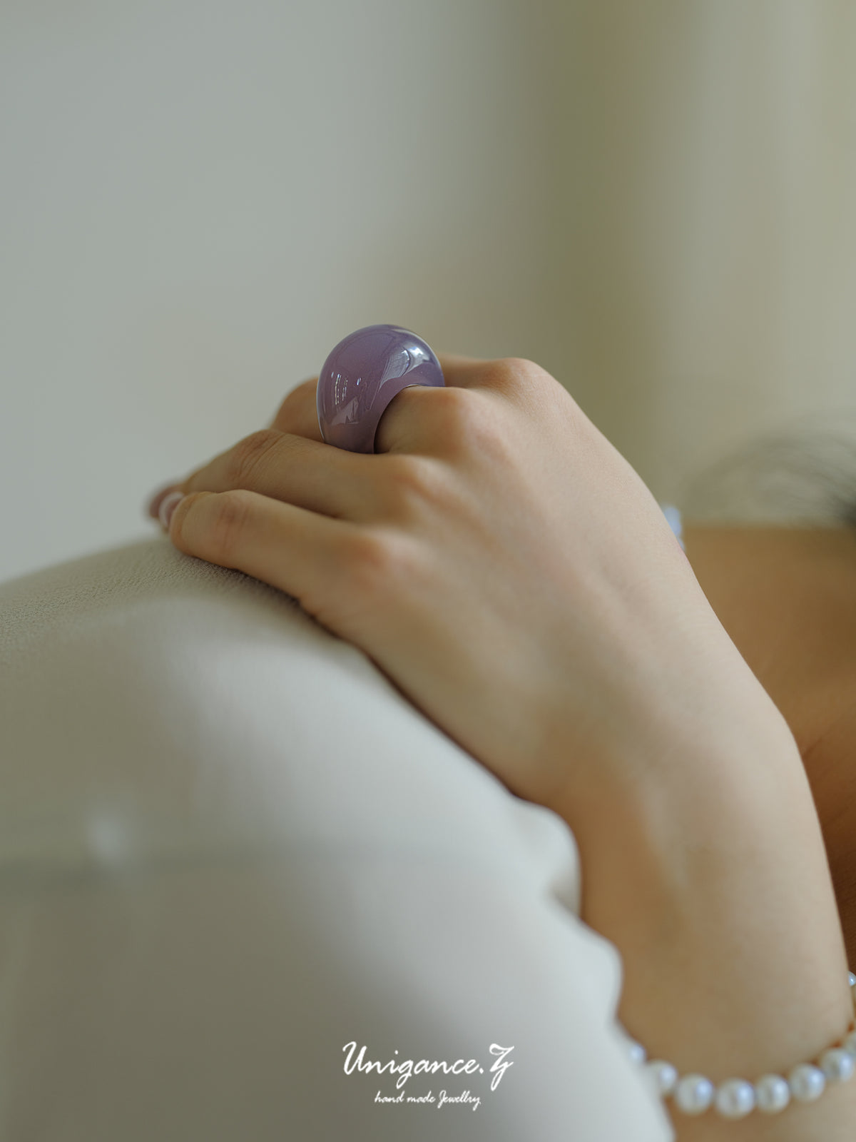 Smoky Purple Jade Band Ring — Hand wearing a purple ring on a blurred background