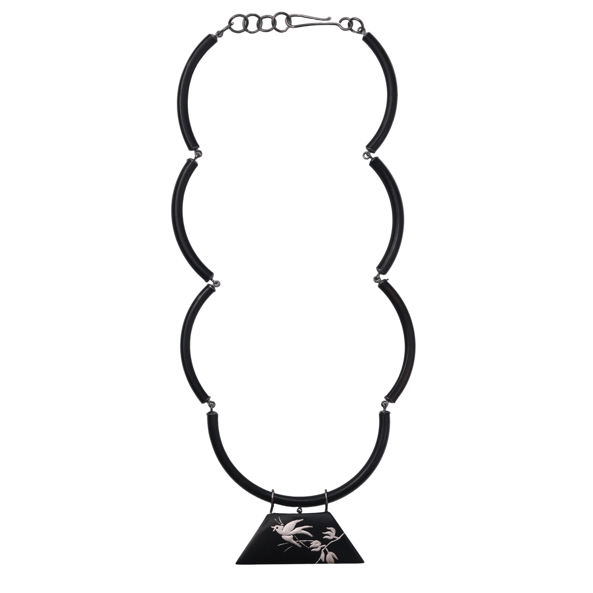 Black necklace with a triangular pendant on a light gray background