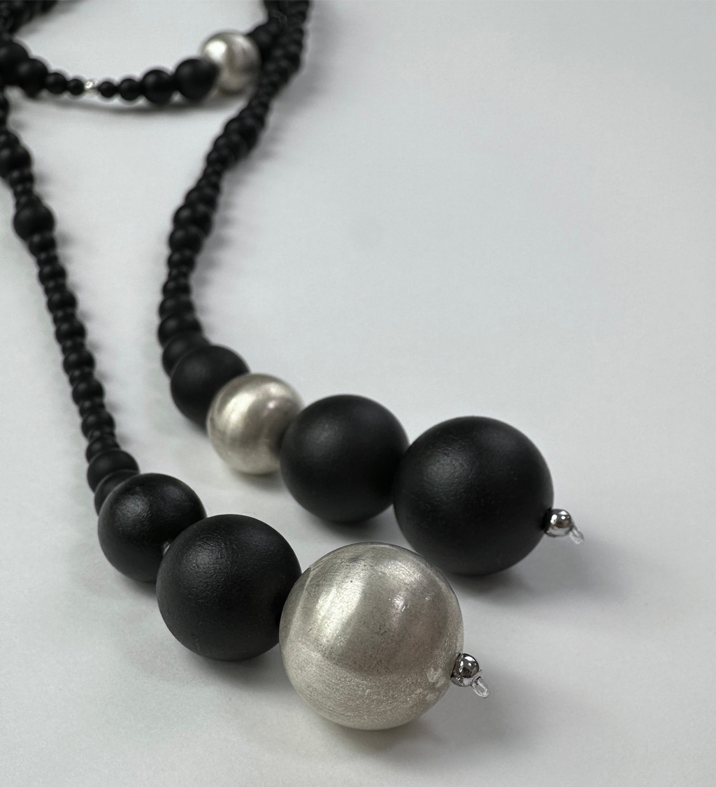 Snow Sparrow Lacquer Quasi-Maki-e Long Lariat Necklace — Necklace with black and silver beads on a light gray background
