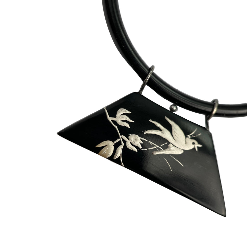 Snow Sparrow Lacquer Quasi-Maki-e Necklace — Black pendant with white bird design on a black cord against a light gray