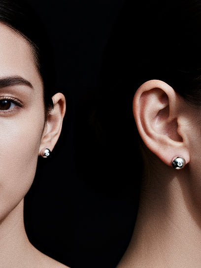 Star Light · Moissanite & Silver Earrings — Close-up of a woman wearing silver earrings on a black background