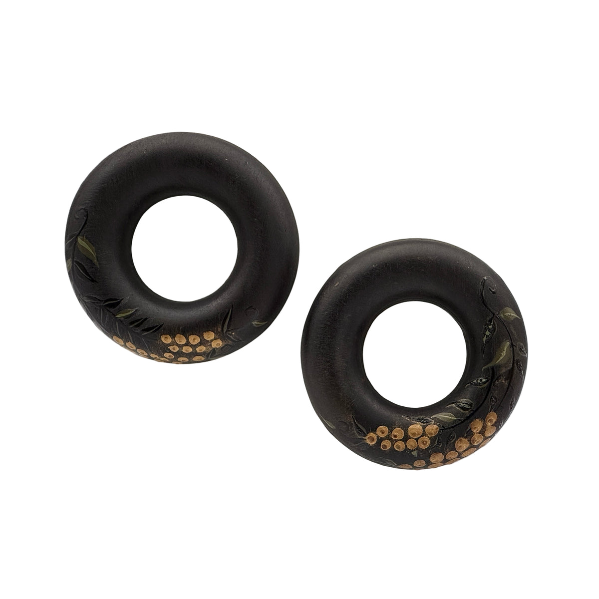 Tenjiku Black Lacquer Quasi-Maki-e Earrings — Two black rubber donut grips on a white surface