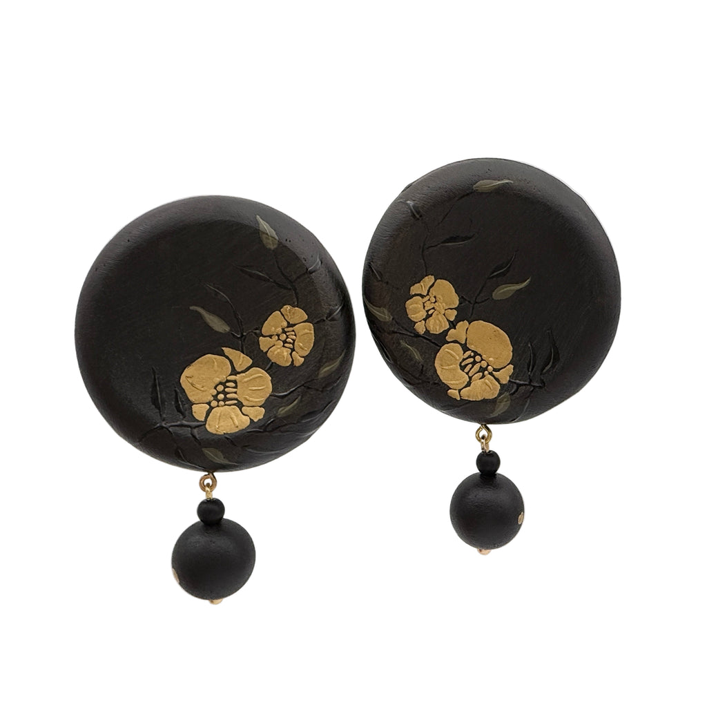 Twin Blossoms Black Lacquer Drop Earrings — Black earrings with gold floral designs on a clear background