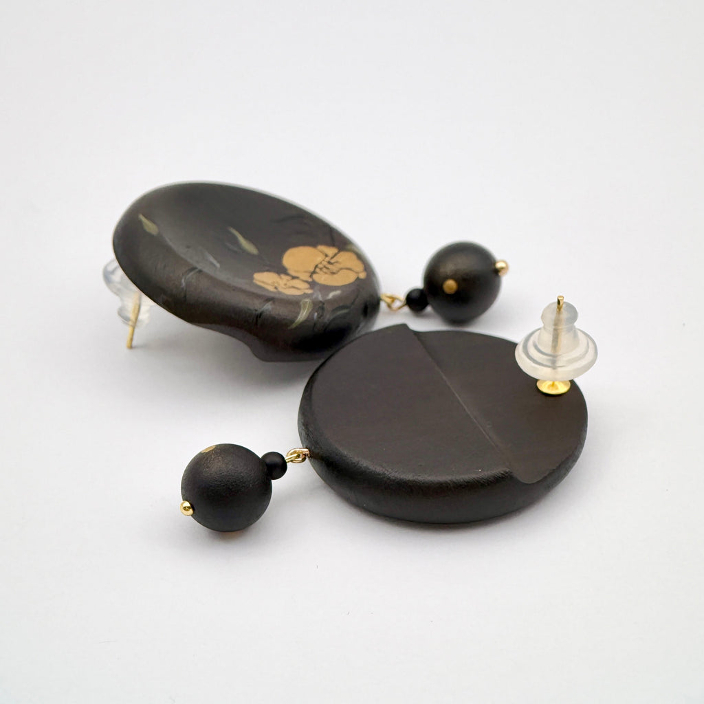 Twin Blossoms Black Lacquer Drop Earrings — Pair of black earrings with gold accents on a white background