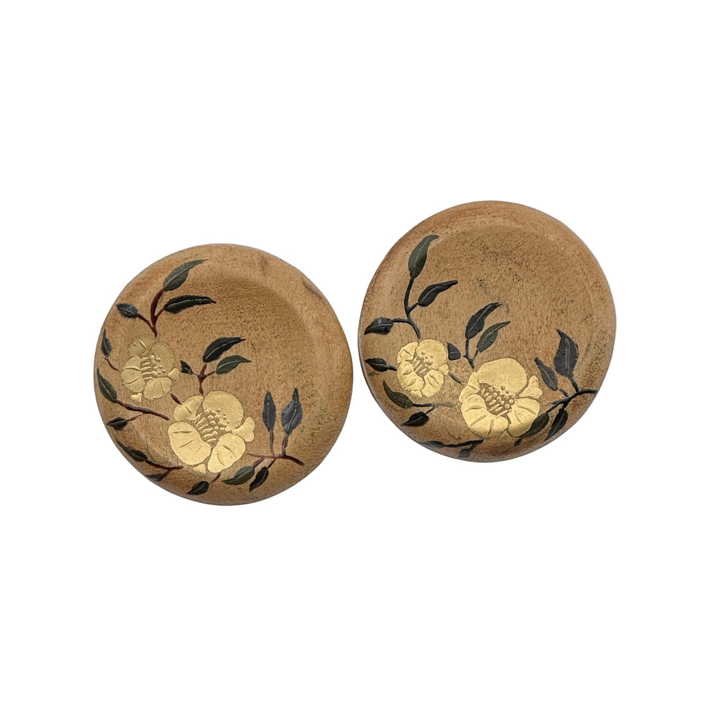 Twin Blossoms Natural Lacquer Earrings — Two round cork coasters with floral designs on a white background